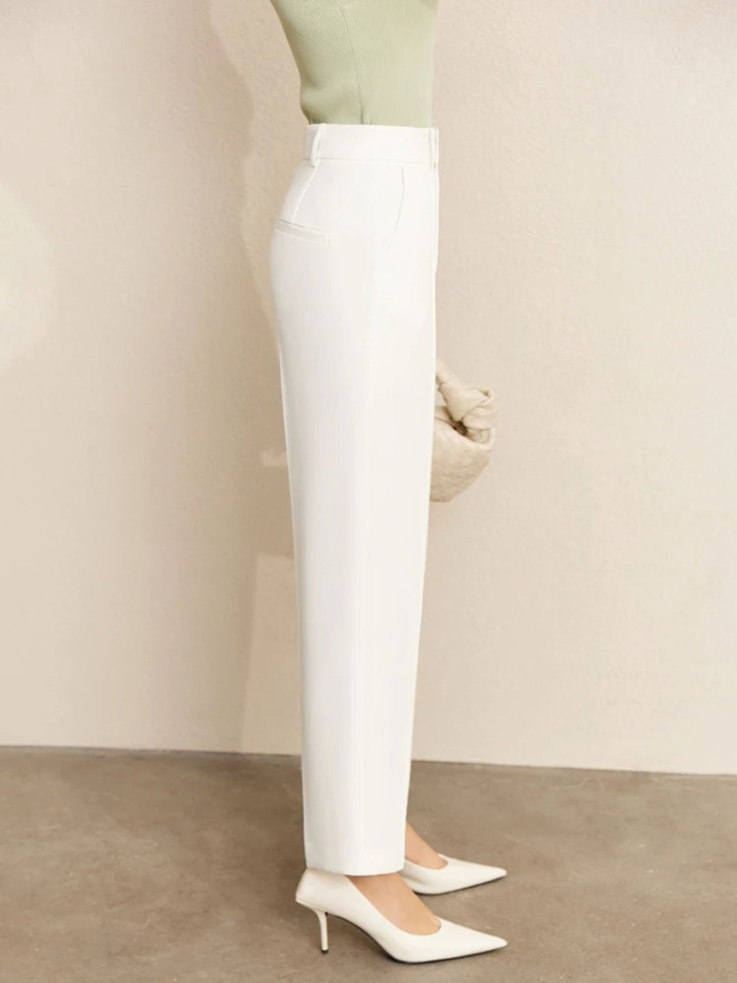 Side view of white trousers with clean hem and pointed heels