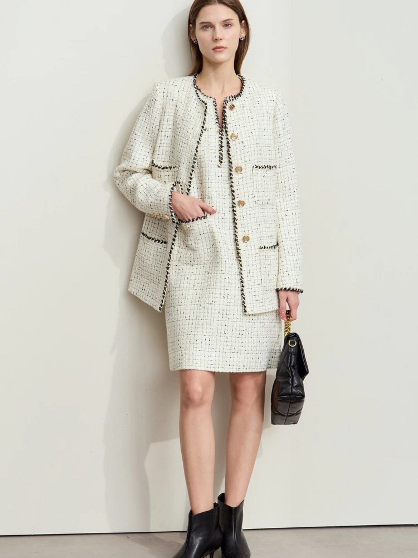 Ivory tweed jacket and skirt set styled with black boots and handbag