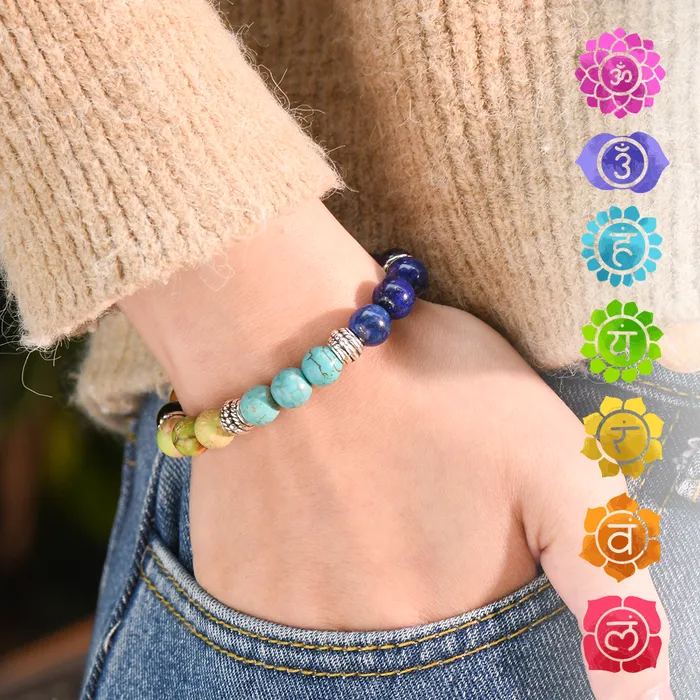 Female model in a brown knitted long sleeve and denim pants wearing a colorful beaded bracelet plus chakra symbols on the side.