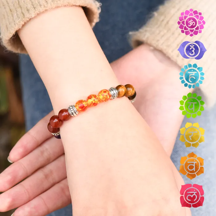 Female model in a brown knitted long sleeve and denim pants wearing a colorful beaded bracelet plus chakra symbols on the side.