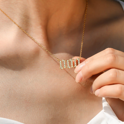 Gold chain necklace with three gold zero digits pendant with white stones worn by a young female