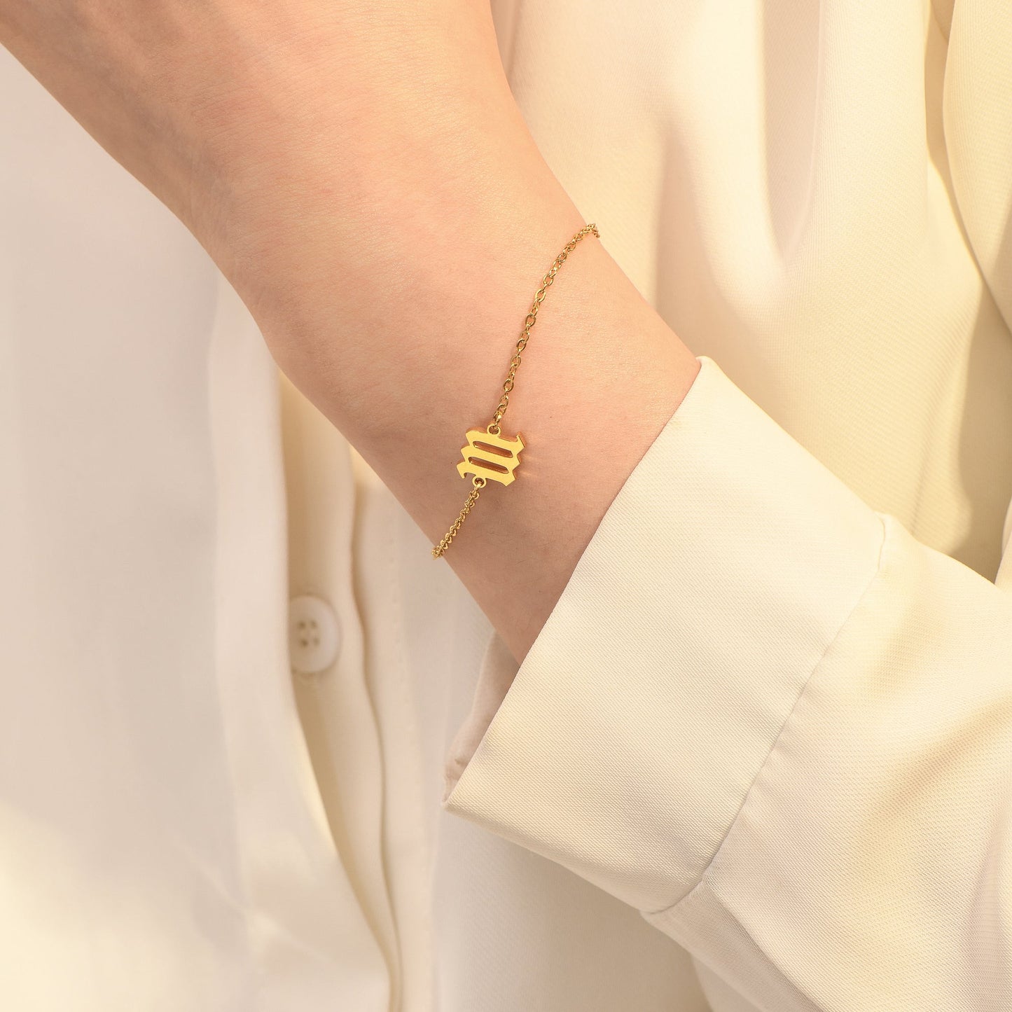 Gold angel number 111 bracelet on woman's wrist wearing a yellow long sleeve