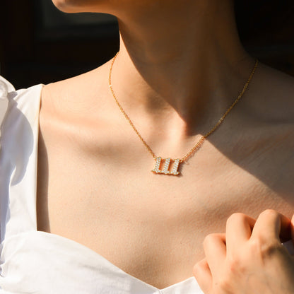 Gold chain necklace with angel number 111 with white stones pendant worn by a young woman