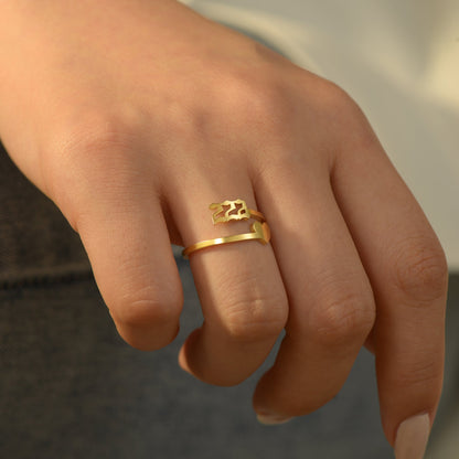 Gold angel number 222 and heart ring on a woman's ring finger