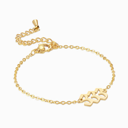 Gold angel number 333 bracelet on a white background