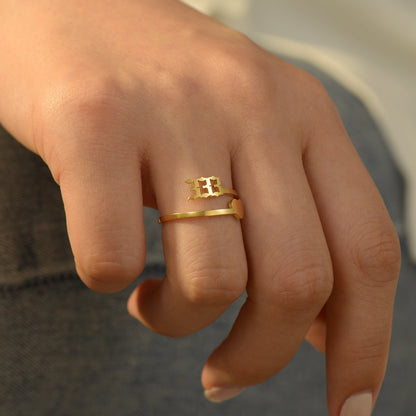 A gold ring with angel number 333 and heart symbol on a woman's ring finger 