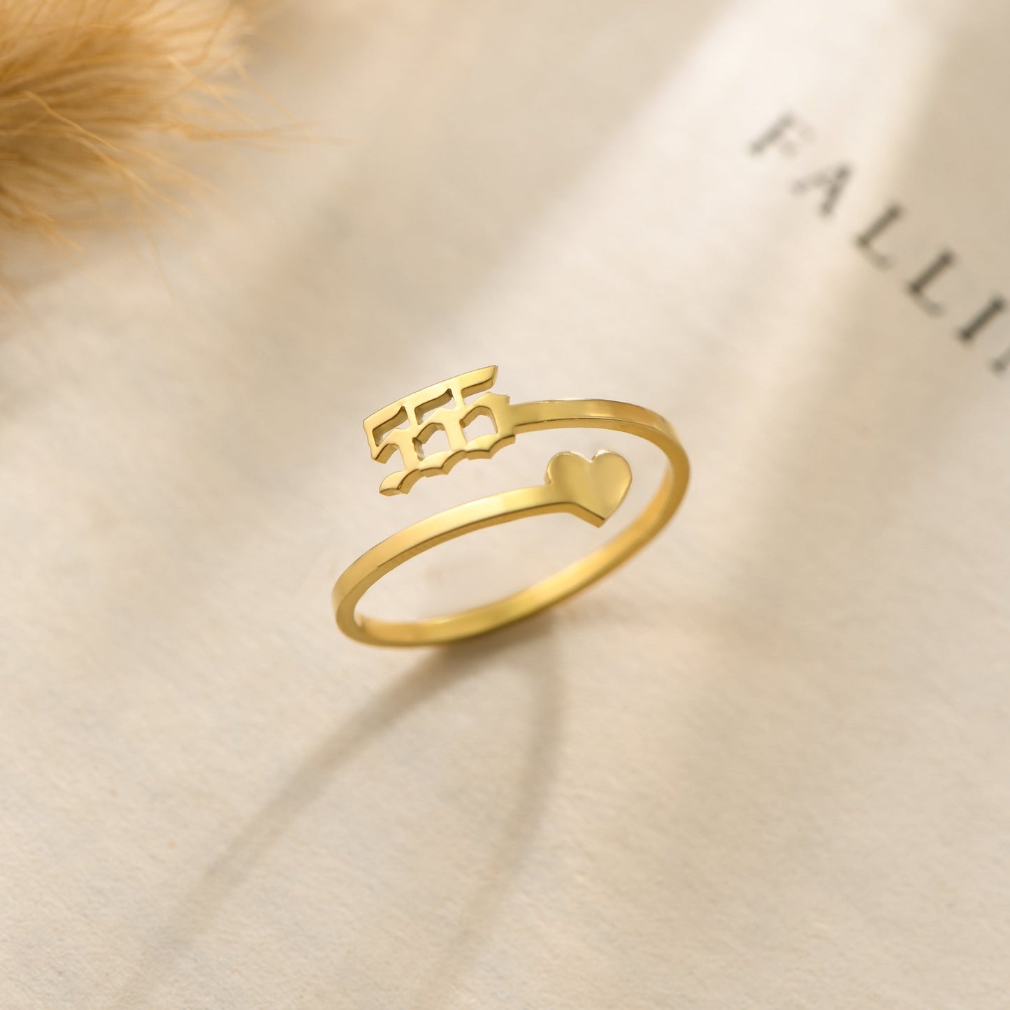 A gold ring with angel number 555 and a heart symbol on a bookpage