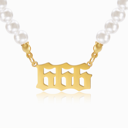 Pearl chain necklace and gold angel number 666 pendant on white background