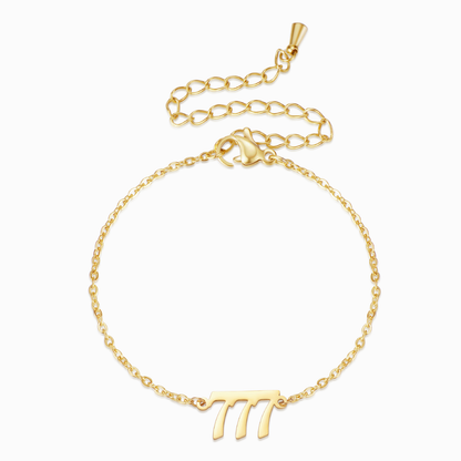 Gold bracelet with gold angel number 777 on white background