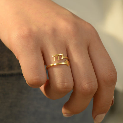 A gold ring with angel number 777 and heart symbol on a woman's ring finger