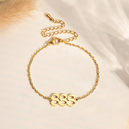 Gold chain bracelet with gold angel number 888 on light background