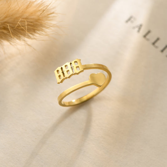 A gold ring with angel number 888 and a heart symbol on a bookpage