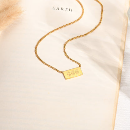 Gold chain necklace with angel number 999 on a book page