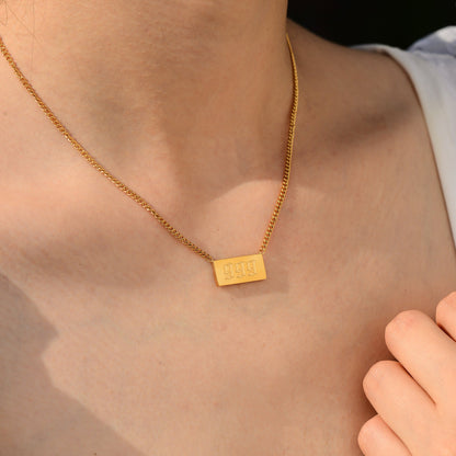 Gold chain necklace with angel number 999 worn by a woman