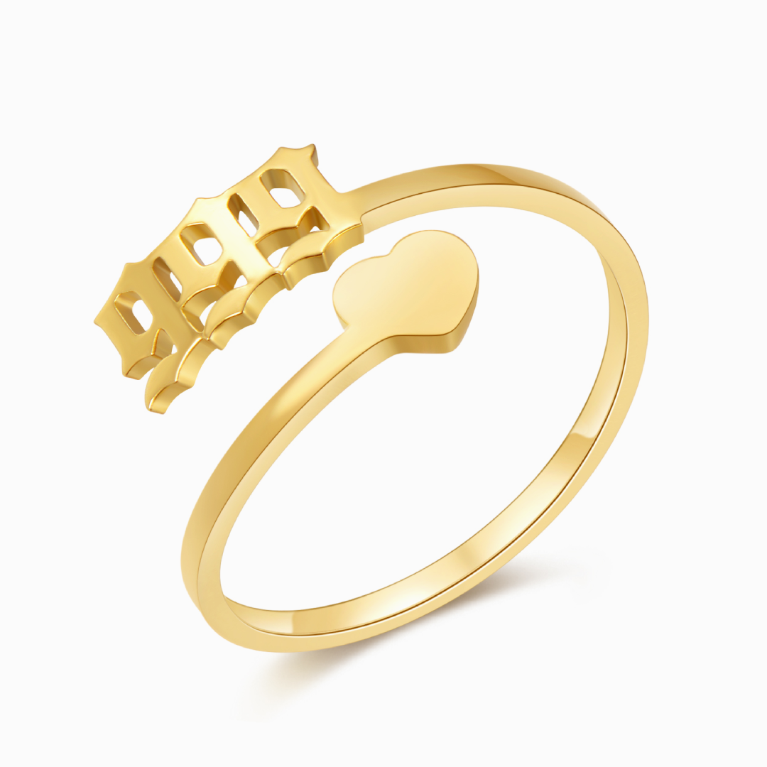 A gold ring with angel number 999 and heart symbol on a white background