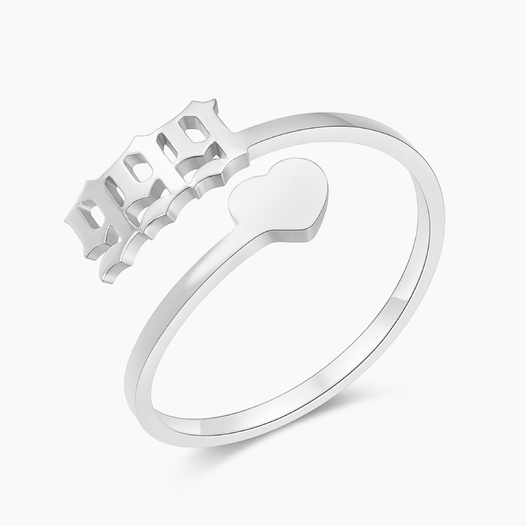 A silver ring with angel number 999 and heart symbol on a white background