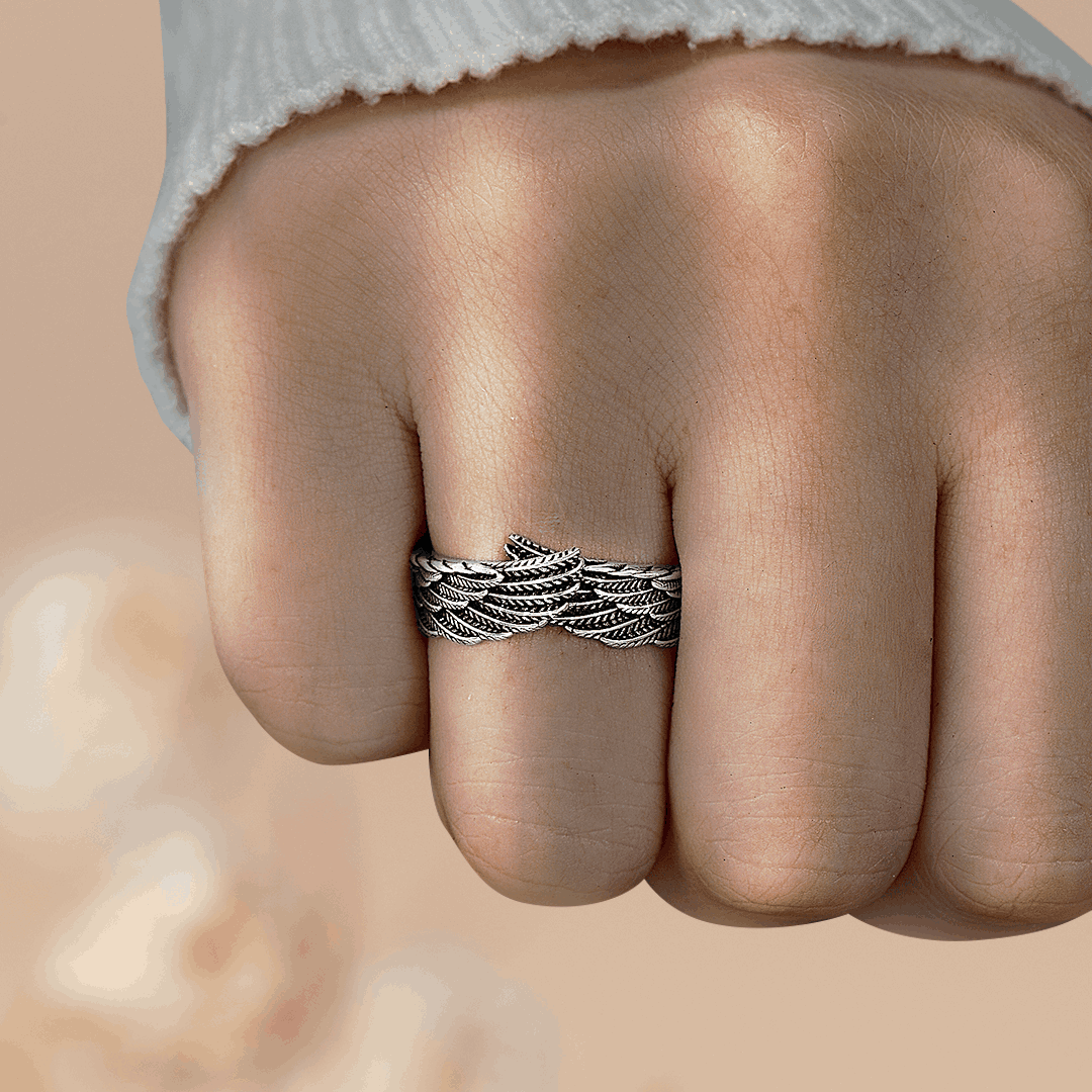 Silver wings ring on woman's ring finger