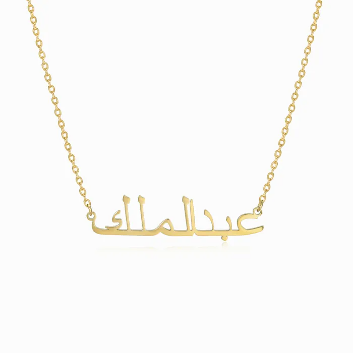 Gold necklace with Arabic engraved name on white background.