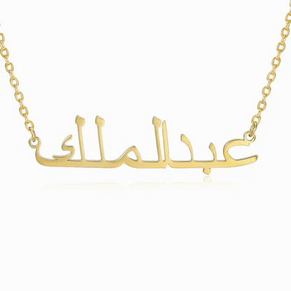 Gold necklace with Arabic engraved name on white background.