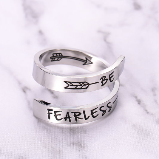 Silver twisted ring with text engraving on marble background