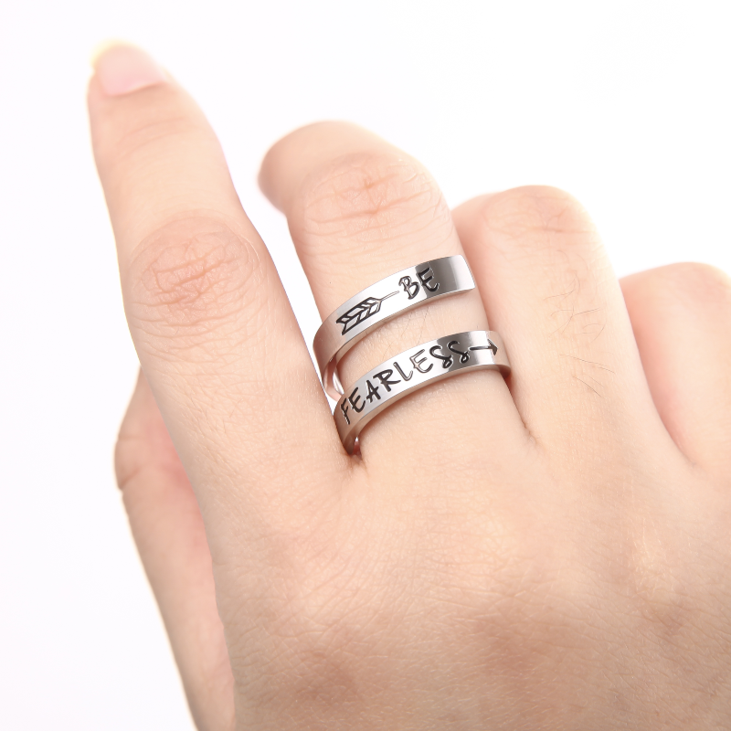 Silver twisted ring with text engraving on female's middle finger