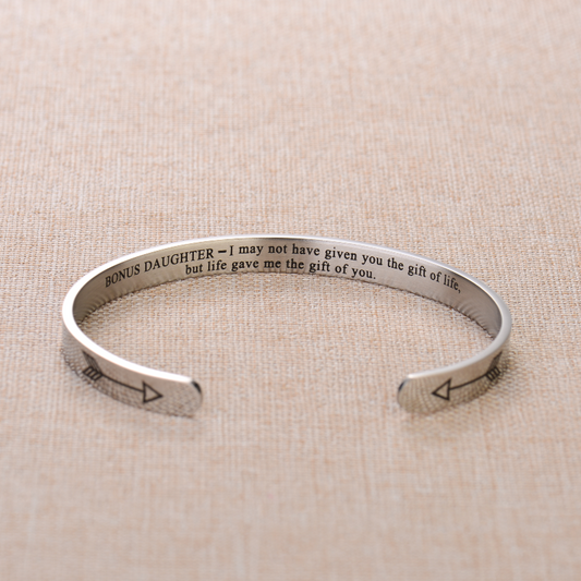 Silver bracelet engraved with text on plain canvas