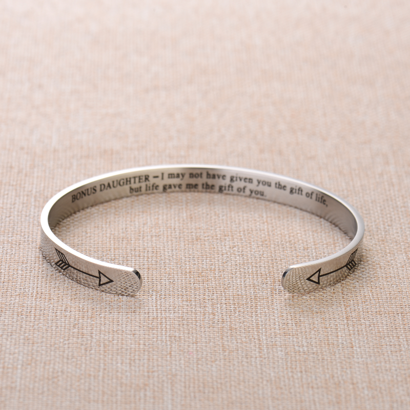 Silver bracelet engraved with text on plain canvas