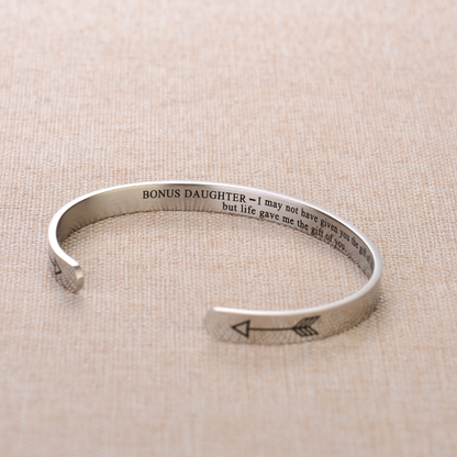 Silver bracelet engraved with text on a plain canvas