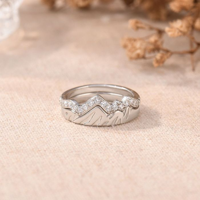 silver mountain rings with small stones stack together on a floral background