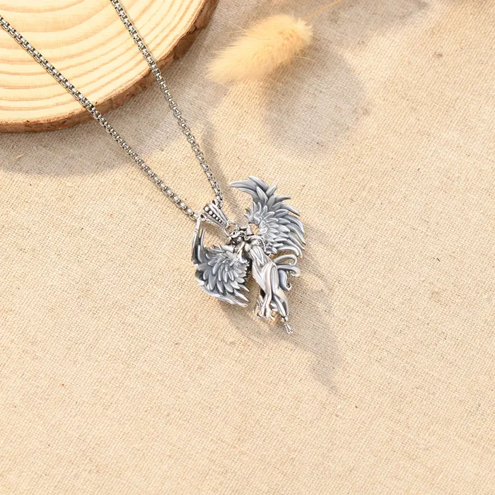 A silver angel necklace on a plain canvas.