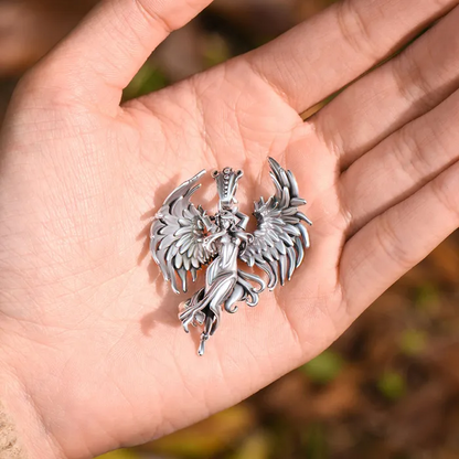 A silver angel pendant on a palm.