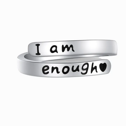 Silver ring with text engraving of "I am enough" on a white background