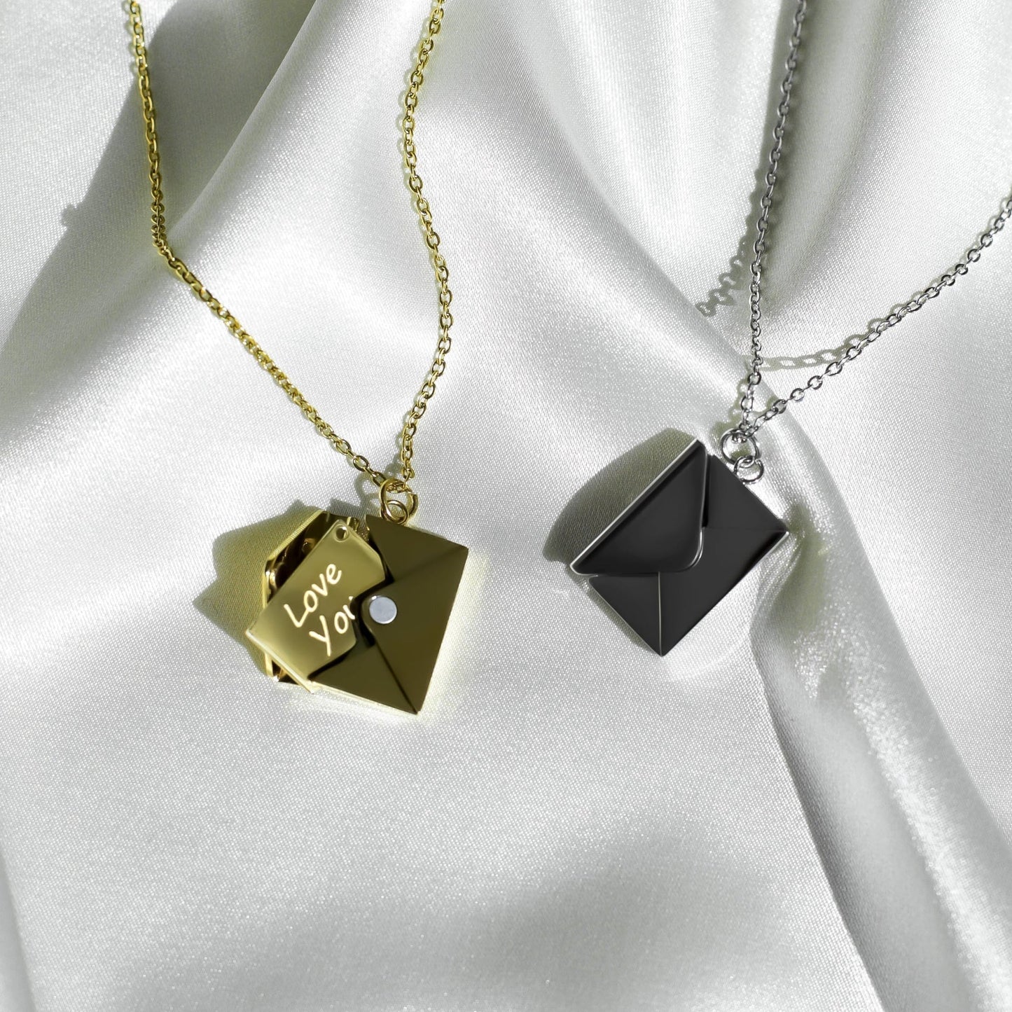 A set of gold and silver chain necklaces with envelope-shaped pendants, each containing a card engraved with 'Love you.