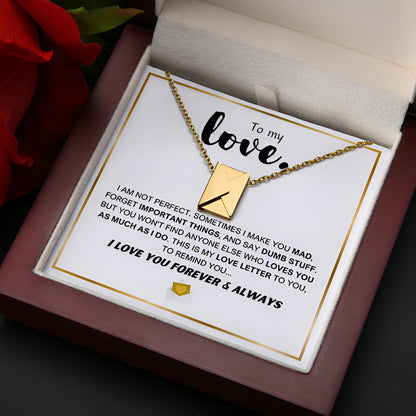 A gold chain necklace with an envelope-shaped pendant displayed on a gift box complete with a with a heartfelt message from a lover to their lover.