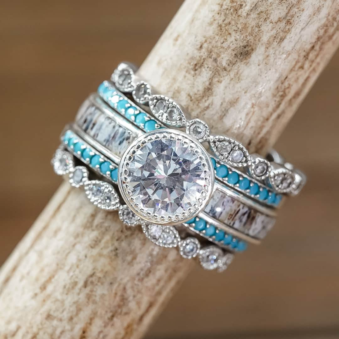 Silver rings embellished with stones and turquoise colored designs on a stick