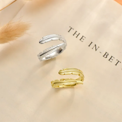 Silver and gold feather-like rings on a book page.