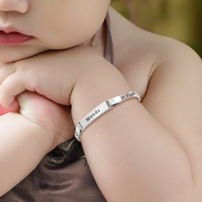 A silver plated personalized name bracelet on a baby's wrist