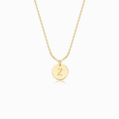 A gold necklace with one personalized initial gold disc on a white background