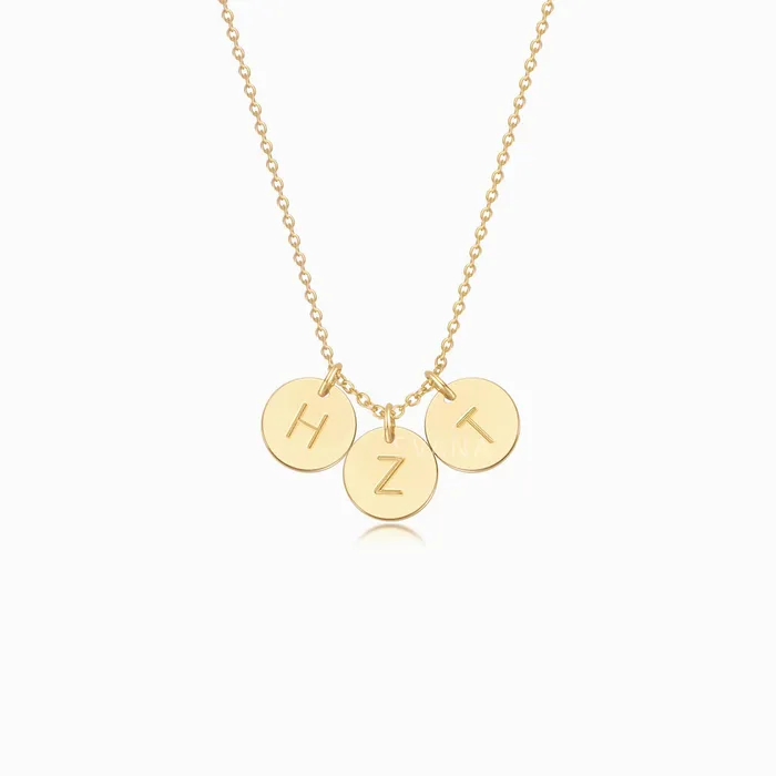 A gold necklace with three personalized initial gold discs on a white background