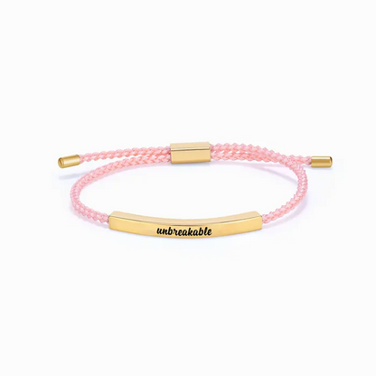 pink rope with gold bar with "unbreakable" text engraving on a white background