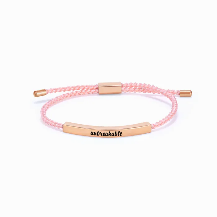 pink rope with rose gold bar with "unbreakable" text engraving on a white background