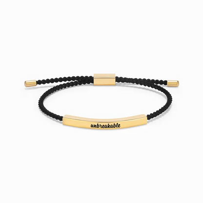 black rope with gold bar with "unbreakable" text engraving on a white background