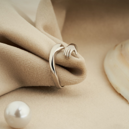 silver hug ring on a beige-colored cloth