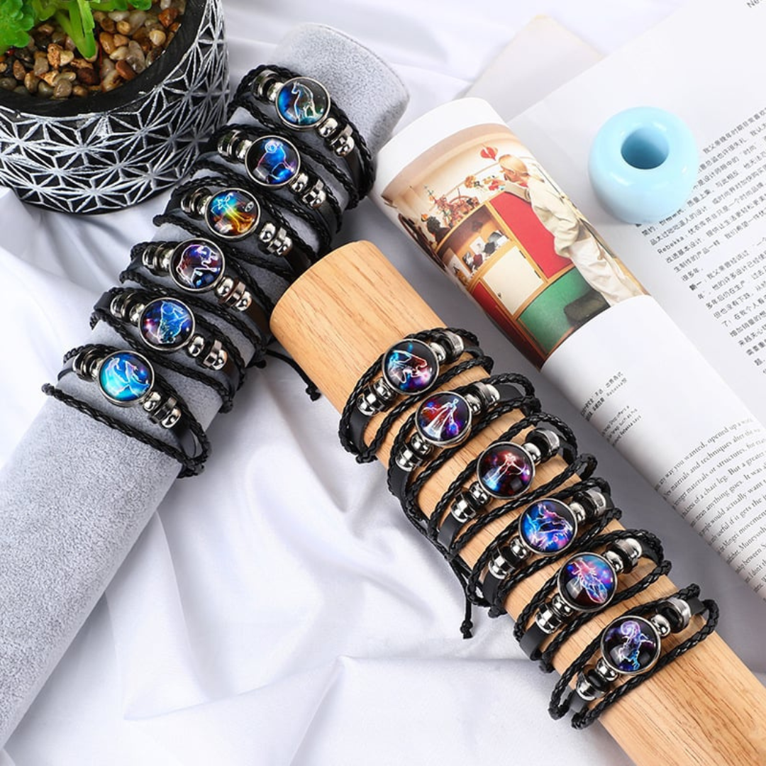 A group of black braided leather bracelets with different circle astrological symbol pendants