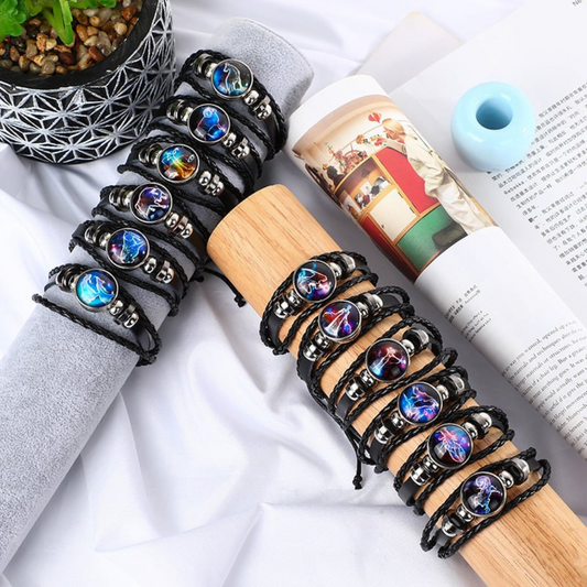 A group of black braided leather bracelets with different circle astrological symbol pendants