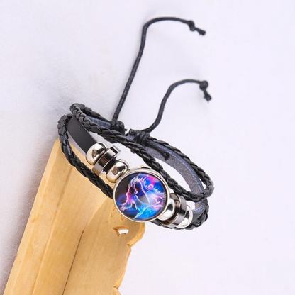 Black braided leather bracelet with a circle pendant that has a Gemini astrological symbol