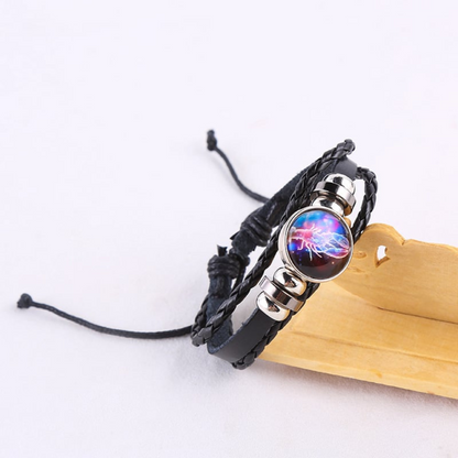 Black braided leather bracelet with a circle pendant that has a Cancer astrological symbol