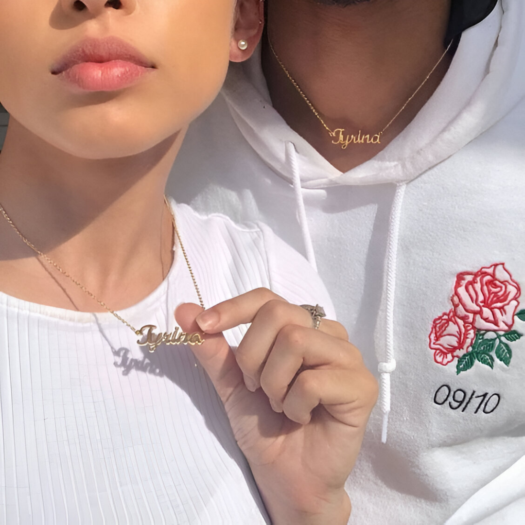 Gold chain necklaces with a customized name pendant being worn by a male model and a female model