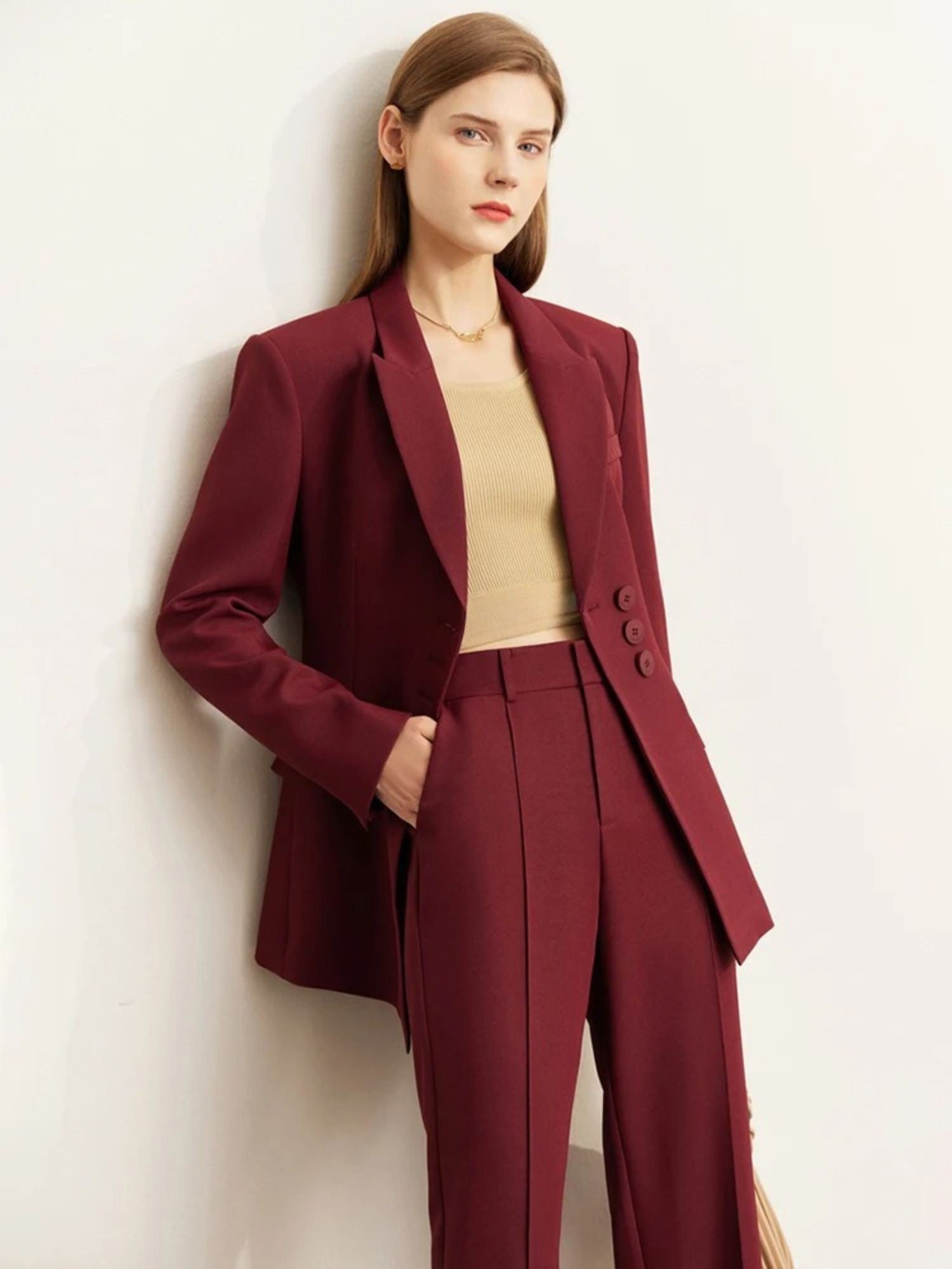 Woman wearing a burgundy suit against a white background