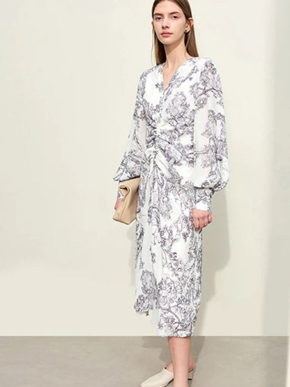 Woman wearing a white floral dress against a plain background
